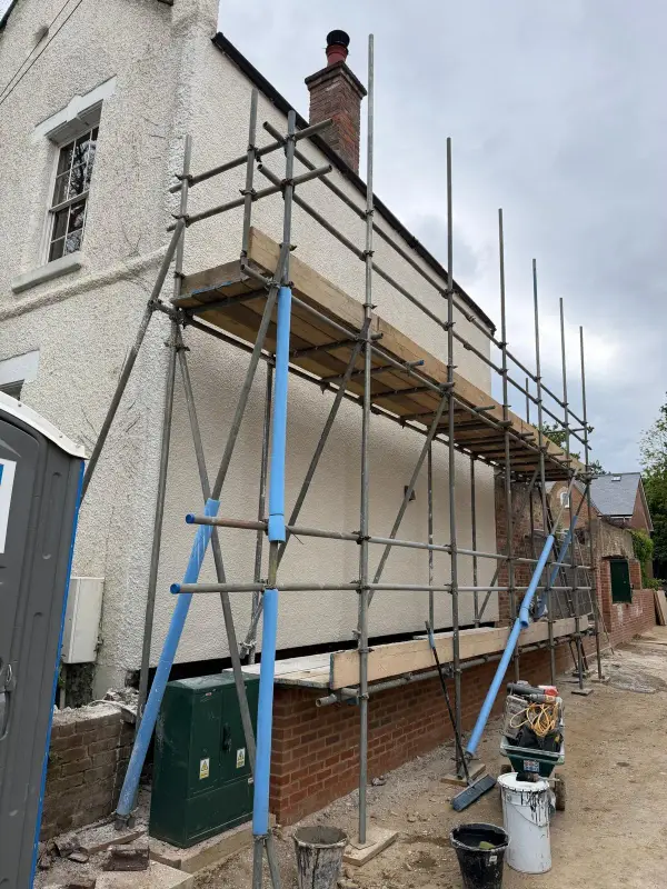 Stage 3: The gable wall finished in off-white textured render, scaffolding still up
