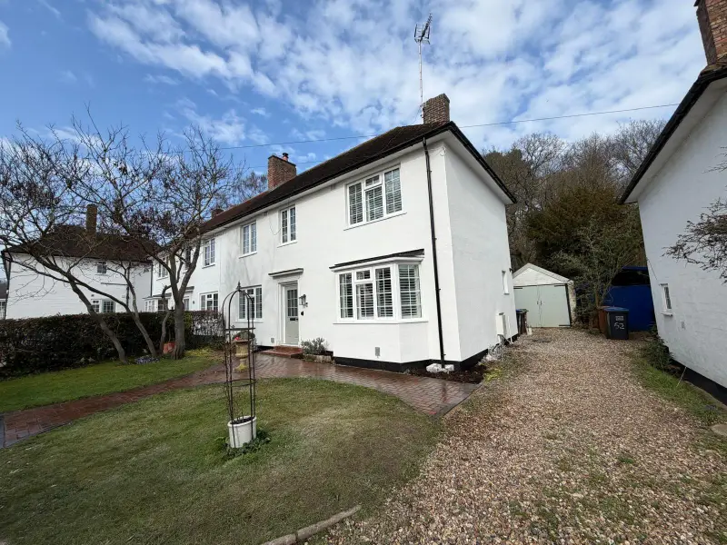 Semi-detached house finished in bright white silicone render with a black plinth